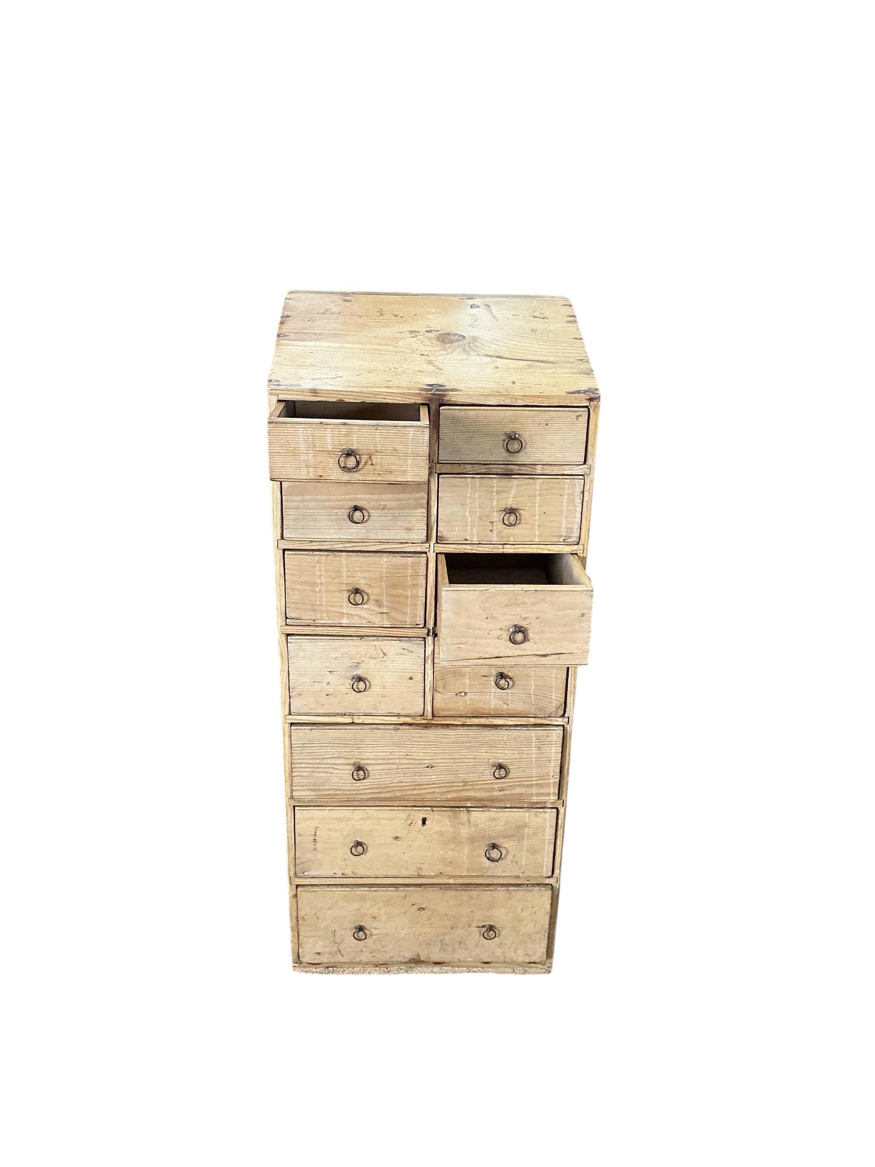 An early 19th century pine eleven drawer campaign chest with slant top, width 33cm, depth 26cm, height 80cm